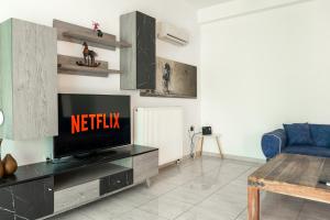 salon z telewizorem i niebieską kanapą w obiekcie King home Larissa city w mieście Larisa