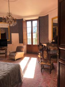 een slaapkamer met een bed, een stoel en een raam bij Château de la Cazette in Sisteron