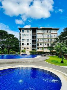 a hotel with a large building in the background at Amaia Steps Nuvali fully furnished unit with swimming pool view near Carmelray Pitland in Calamba