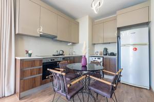 cocina con mesa, sillas y nevera en 212 Outlet karsisinda Lux residence N7, en Estambul