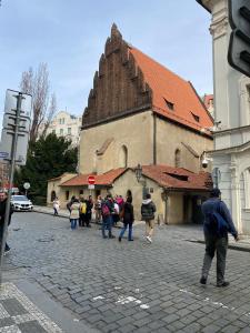 un groupe de personnes marchant devant un bâtiment dans l'établissement Golem, à Prague