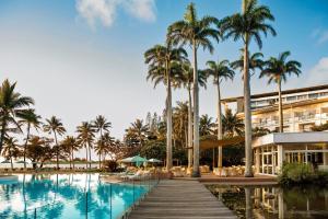 un complejo con piscina, palmeras y un edificio en Le Méridien Nouméa Resort & Spa, en Noumea