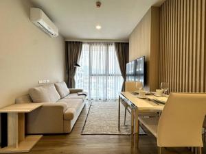 een woonkamer met een bank en een tafel bij 2 Bedroom Skypark Condo Laguna in Bang Tao Beach