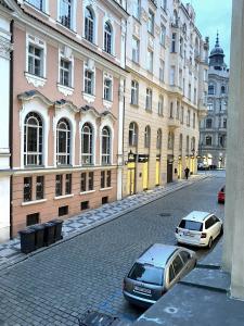 deux voitures garées dans une rue en face des bâtiments dans l'établissement Golem, à Prague