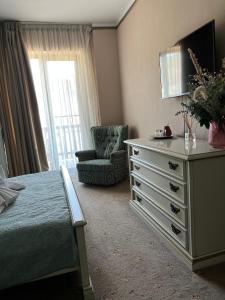 a bedroom with a dresser with a tv and a chair at Pensiunea Baroc in Braşov