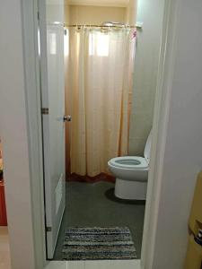 a bathroom with a toilet and a shower at Cozy studio unit in a condominium in Iloilo City