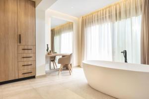 a bathroom with a tub and a table at Mamfredas Luxury Residence in Plános