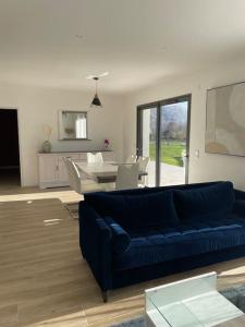 sala de estar con sofá azul y mesa en Maison au cœur des Pyrénées !, en Ayzac-Ost