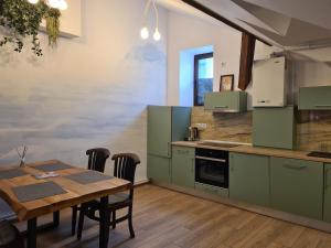 eine Küche mit grünen Schränken und einem Holztisch in der Unterkunft ELEMENTS HAUS in Sibiu