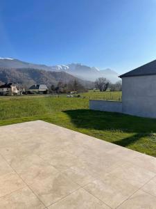 a large concrete walkway next to a field with mountains at Maison au cœur des Pyrénées ! in Ayzac-Ost