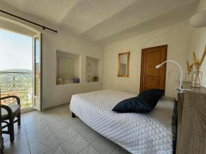 1 dormitorio con cama y ventana grande en Alla Casa - Appt pour 6 avec terrasse en Aregno