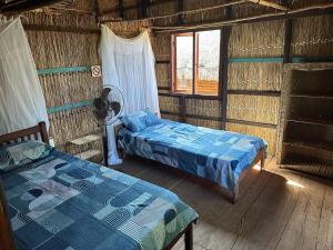 a room with two beds and a window at Paradise Dunes in Praia do Tofo