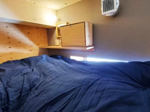 - un lit avec une couette bleue dans l'établissement ゲストハウス EZO Run Sapporo 札幌中心部でシンプルな滞在ができるホステル, à Sapporo