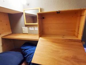 Ce lit superposé se trouve dans un dortoir doté d'une armoire en bois. dans l'établissement ゲストハウス EZO Run Sapporo 札幌中心部でシンプルな滞在ができるホステル, à Sapporo