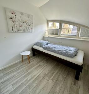 a small bedroom with a bed and two windows at Dünenperle in Zingst
