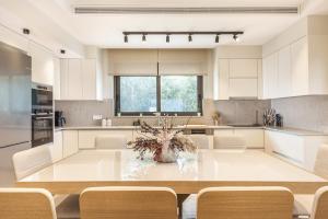 a large white kitchen with a table and chairs at Mamfredas Luxury Residence in Plános