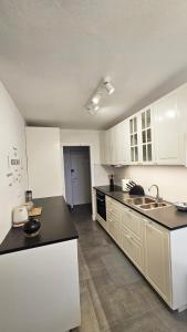eine Küche mit weißen Schränken und einer schwarzen Arbeitsplatte in der Unterkunft Bridge View Apartment Lapad in Dubrovnik