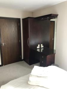 een slaapkamer met houten kasten en een bed met witte lakens bij Riverside Penthouse Apartment in Londonderry County Borough
