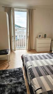 ein Schlafzimmer mit einem Bett und einem großen Fenster in der Unterkunft Bridge View Apartment Lapad in Dubrovnik
