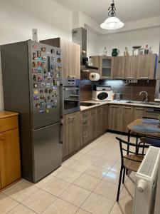 a kitchen with a stainless steel refrigerator with magnets at PlatánWood ComfortHome in Zalaegerszeg