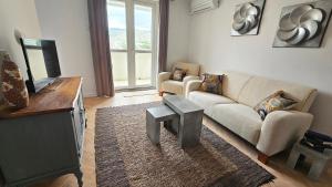 ein Wohnzimmer mit einem Sofa und einem Tisch in der Unterkunft Bridge View Apartment Lapad in Dubrovnik