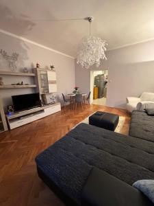 a living room with a couch and a table with chairs at PlatánWood ComfortHome in Zalaegerszeg