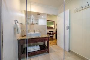a bathroom with a sink and a glass shower at Little Pilgrims Boutique Hotel in Hazyview +50 photos