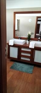 a bathroom with two sinks and a large mirror at Villa Tahoyo - Disfruta con la familia en un entorno tranquilo in Máguez