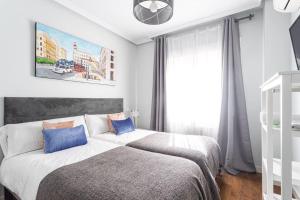 a bedroom with a bed with two blue pillows at Precioso apartamento con vistas excepcionales (Seg.5) in Madrid