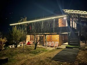 a house with lights on the side of it at night at Woodside Traditional Homestays in Nagar