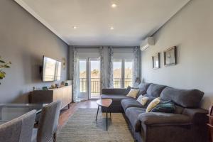 a living room with a couch and a table at Precioso apartamento con vistas excepcionales (Seg.5) in Madrid