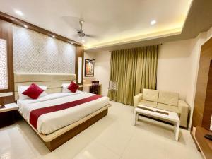 um quarto de hotel com uma cama e uma cadeira em Hotel KP ! Puri near-sea-beach-and-temple fully-air-conditioned-hotel with-lift-and-parking-facility em Puri