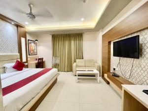 um quarto de hotel com uma cama e uma televisão de ecrã plano em Hotel KP ! Puri near-sea-beach-and-temple fully-air-conditioned-hotel with-lift-and-parking-facility em Puri