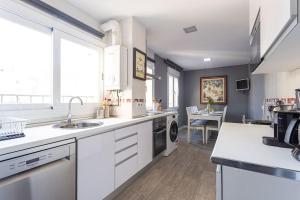 a kitchen with white cabinets and a sink at Precioso apartamento con vistas excepcionales (Seg.5) in Madrid