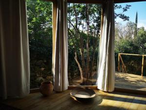 a room with a large window and a bowl on a wooden floor at Yourte au coeur du village in Fontvieille