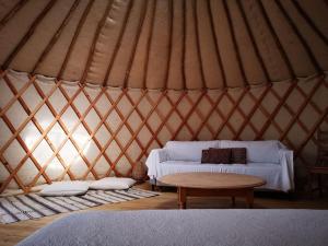 a yurt with a couch and a table in it at Yourte au coeur du village in Fontvieille