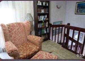 a living room with a chair and a book shelf at Vila Marija in Podgorica