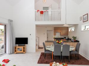 a living room with a dining table and a kitchen at Narracott Down in South Molton