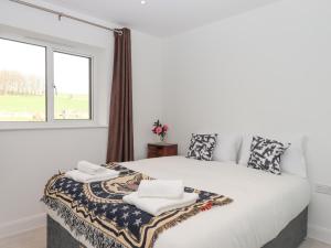 a white bedroom with a large bed with towels on it at Narracott Down in South Molton