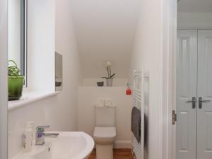 a white bathroom with a toilet and a sink at Narracott Down in South Molton +47 photos