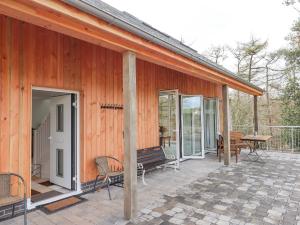 a porch of a wooden house with a bench and a table at Narracott Down in South Molton