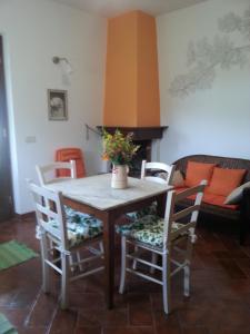 een tafel en stoelen in de woonkamer bij Il Mandorlino Pitigliano appartamento in tipico casale maremmano con portico e giardino in Pitigliano
