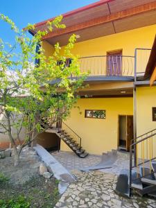 una casa amarilla con una escalera delante de ella en CELENTANO, en Dilijan