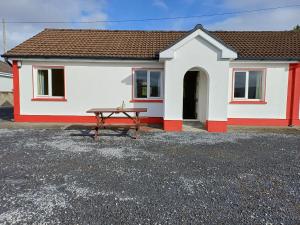 a house with a picnic table in front of it at Robins Roost Cornamona in Cornamona