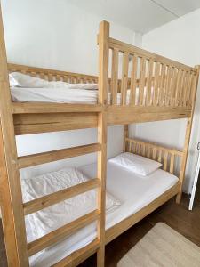チェンカーンにあるLe Moon Hotelの木製の二段ベッド(白いシーツ、枕付)