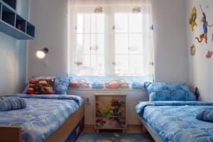 una camera per bambini con due letti e una finestra di Apartment Dino a Selce
