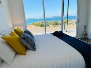 a bedroom with a bed with a view of the ocean at Wild Retreat - Luxury Home with Magnificent Views in Vivonne Bay