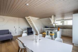 a kitchen and living room with a white table and chairs at 4-bedroom house with sea view and hot tub in Ilulissat
