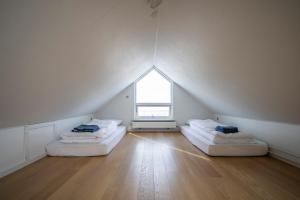 an attic room with two beds and a window at 4-bedroom house with sea view and hot tub in Ilulissat
