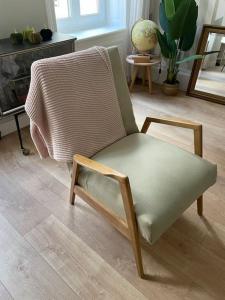 een stoel in een woonkamer naast een open haard bij Le grand Louis, hypercentre in Cherbourg en Cotentin